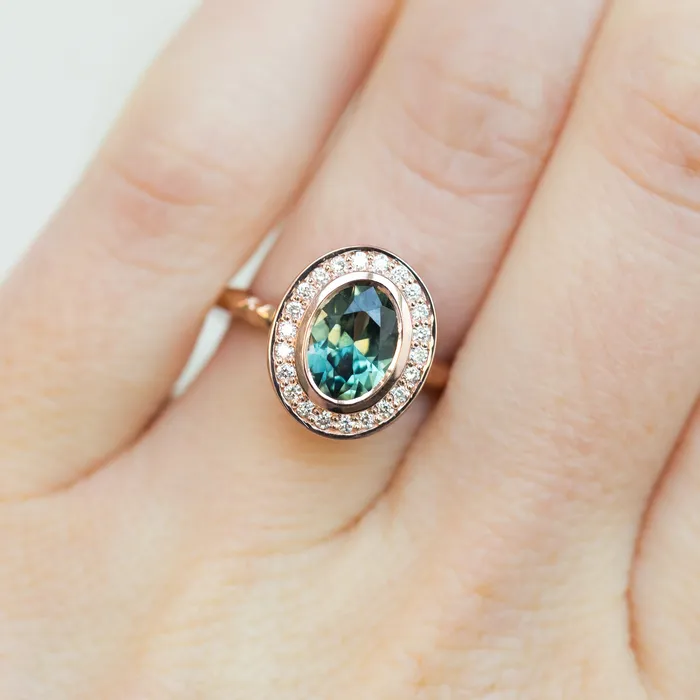 Rings Anueva Jewelry Oval Bezel Set 149ct Color Changing Teal Sapphire and Diamond Halo Engagement Ring 14k Rose Gold Evergreen Band Rings Anueva Jewelry Oval Bezel Set 149ct Color Changing Teal Sapphire and Diamond Halo Engagement Ring 14k Rose Gold Evergreen Band